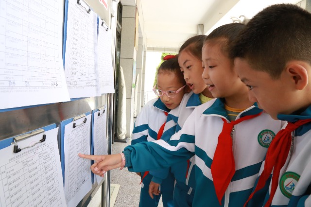 甘州區(qū)北街小學(xué)孩子在圍觀公示出的作業(yè)清單(張儒泰攝).JPG 甘州區(qū)北街小學(xué)孩子在圍觀公示出的作業(yè)清單(張儒泰攝).JPG
