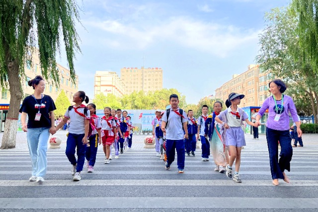 01 臨澤縣城關(guān)小學“紅燭先鋒”護學崗教師護送學生放學。謝靜 攝.jpg