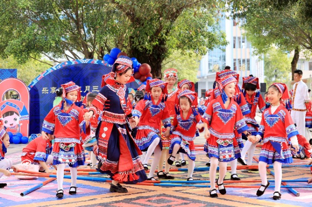 圖4：4月9日，在廣西柳州市融安縣實(shí)驗(yàn)小學(xué)校園，一名老師帶著學(xué)生跳竹竿舞。（譚凱興 攝）.JPG