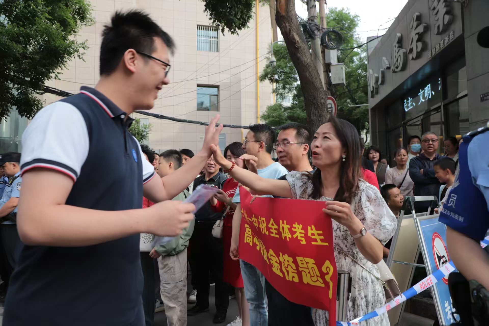 首場考試開考前，蘭州一中教師在考場外暖心陪考送祝福，鼓勵(lì)學(xué)生從容應(yīng)對。（馬綺徽 攝）.jpg
