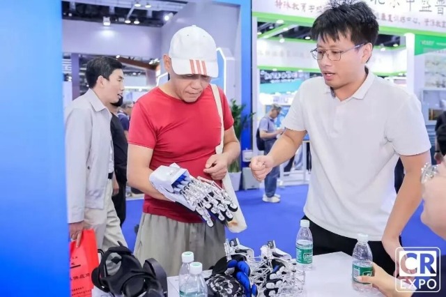 于金須在博覽會上向來賓介紹手部康復(fù)機器人 學(xué)校供圖.jpg